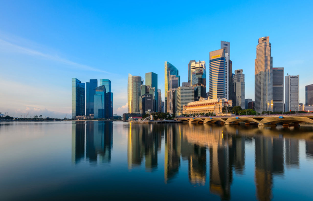 The skyline of Singapore and the image reflected in water as seen from the bay.